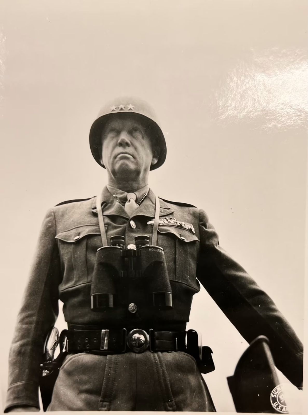 General Patton in his helmet with binoculars at his chest